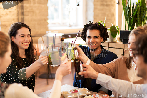 Image of happy friends with drinks at bar or cafe