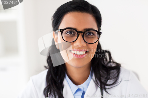 Image of face of happy smiling young doctor in glasses