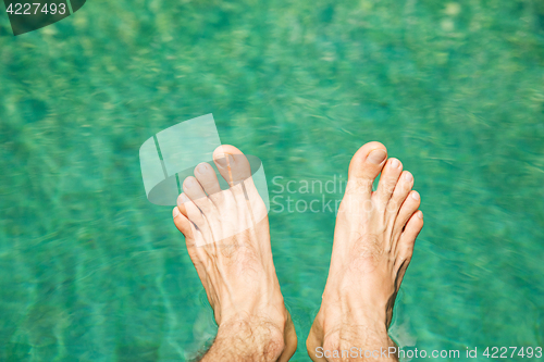 Image of male feet over sea water