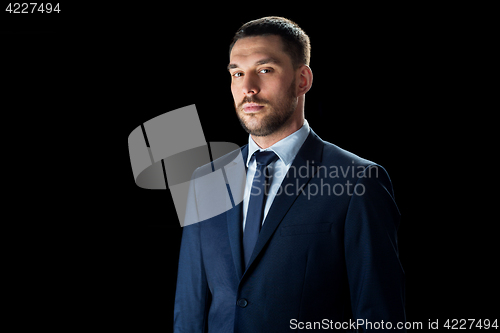 Image of buisnessman in suit over black