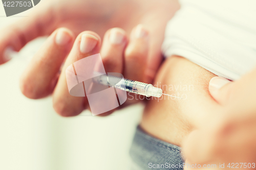 Image of woman with syringe making insulin injection