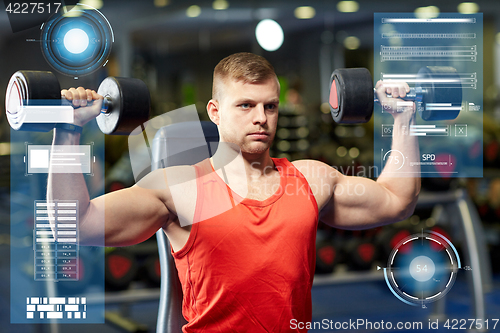 Image of young man with dumbbells flexing muscles in gym