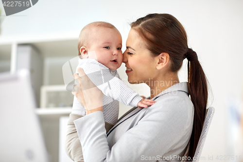 Image of happy businesswoman with baby at office