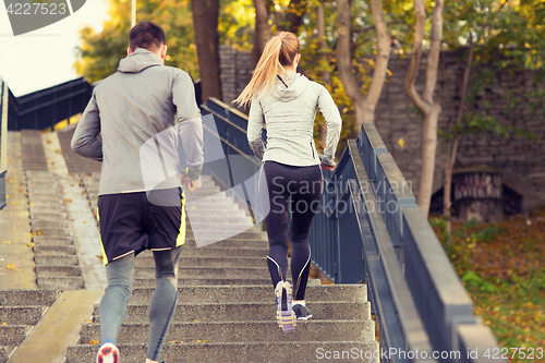 Image of couple running upstairs in city park