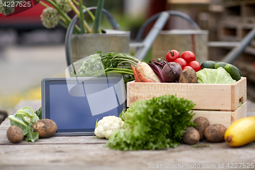 Image of close up of vegetables with tablet pc on farm