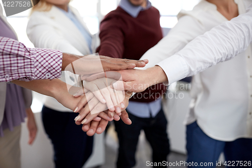 Image of happy business team with hands on top at office