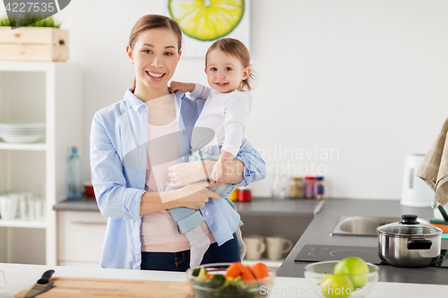 Image of happy mother and little baby girl at home kitchen