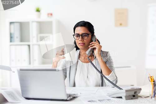 Image of businesswoman calling on phone at office