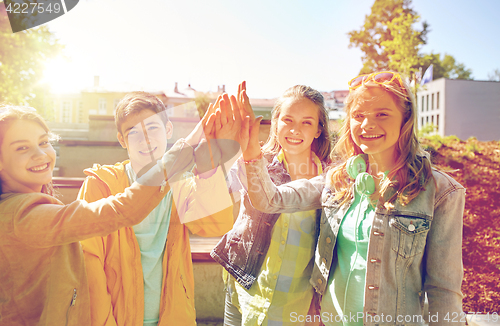 Image of happy students or friends making high five