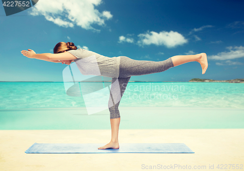 Image of woman making yoga warrior pose on mat