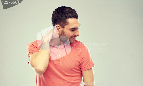 Image of unhappy man suffering from neck pain
