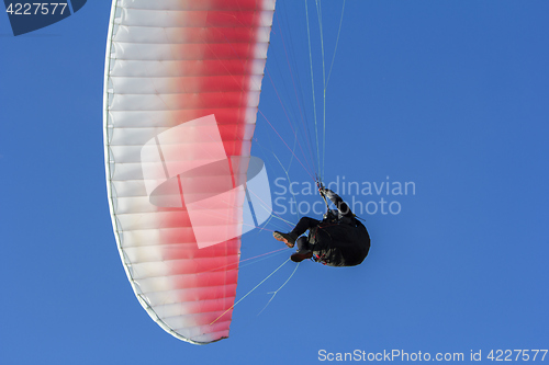 Image of Paraglider flying in the blue sky as background