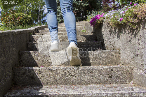 Image of Young woman climbs on concrete stairs