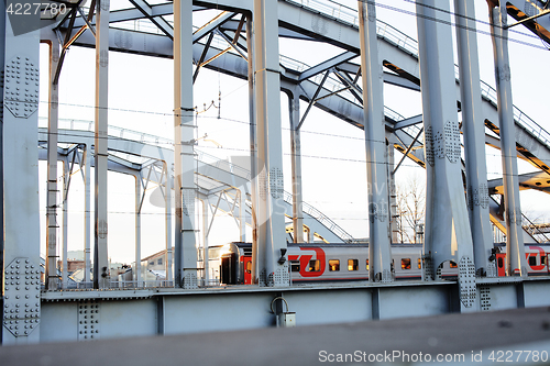 Image of landscape with railway with trains, lot of steel rafters at sunset