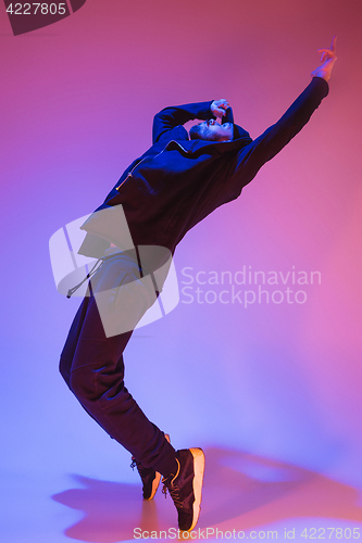 Image of The silhouette of one hip hop male break dancer dancing on colorful background