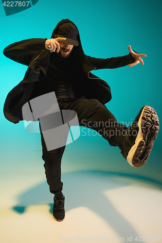 Image of The silhouette of one hip hop male break dancer dancing on colorful background