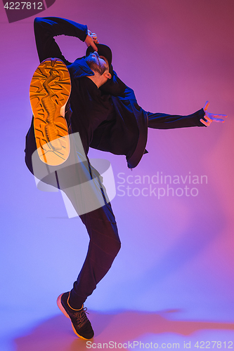 Image of The silhouette of one hip hop male break dancer dancing on colorful background