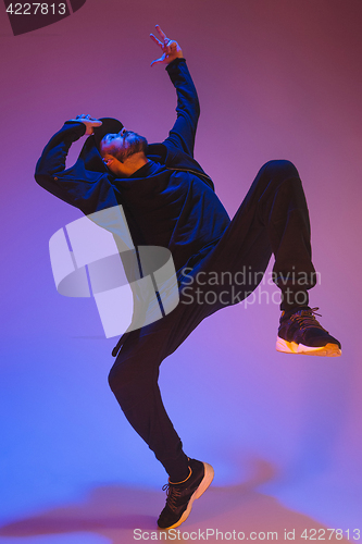 Image of The silhouette of one hip hop male break dancer dancing on colorful background