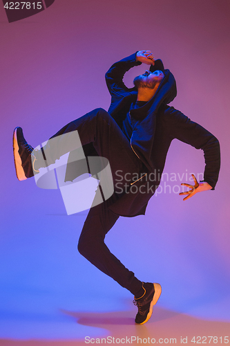 Image of The silhouette of one hip hop male break dancer dancing on colorful background