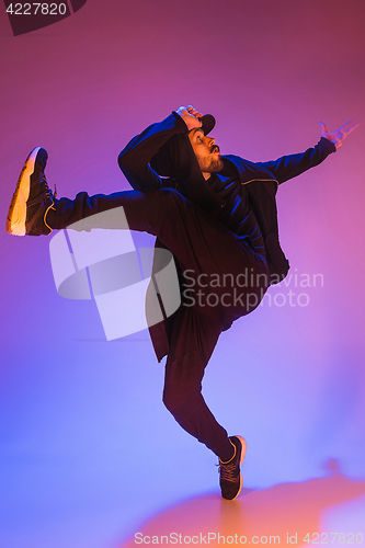 Image of The silhouette of one hip hop male break dancer dancing on colorful background