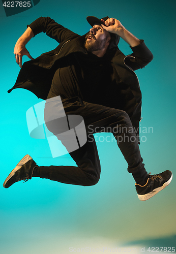 Image of The silhouette of one hip hop male break dancer dancing on colorful background