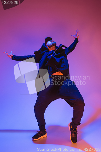 Image of The silhouette of one hip hop male break dancer dancing on colorful background