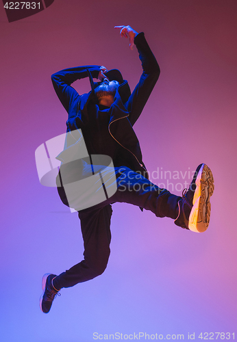 Image of The silhouette of one hip hop male break dancer dancing on colorful background