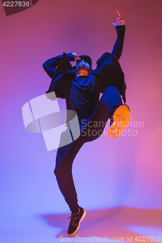 Image of The silhouette of one hip hop male break dancer dancing on colorful background