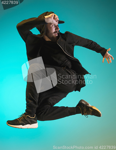 Image of The silhouette of one hip hop male break dancer dancing on colorful background