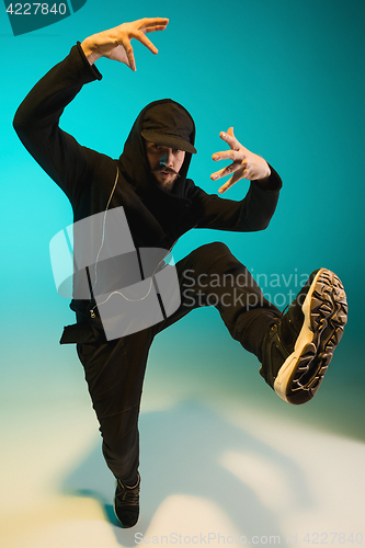 Image of The silhouette of one hip hop male break dancer dancing on colorful background