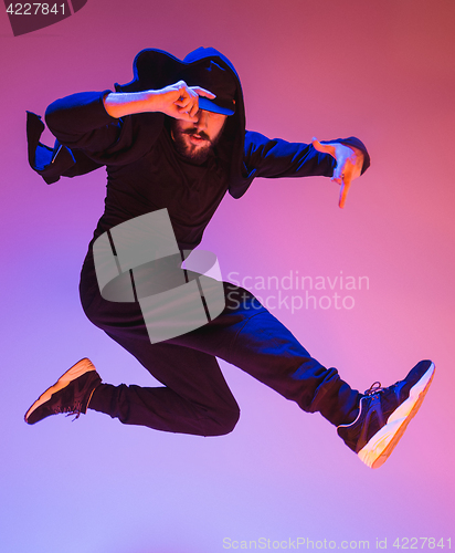 Image of The silhouette of one hip hop male break dancer dancing on colorful background