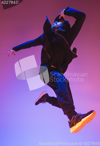 Image of The silhouette of one hip hop male break dancer dancing on colorful background