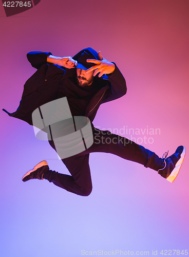 Image of The silhouette of one hip hop male break dancer dancing on colorful background