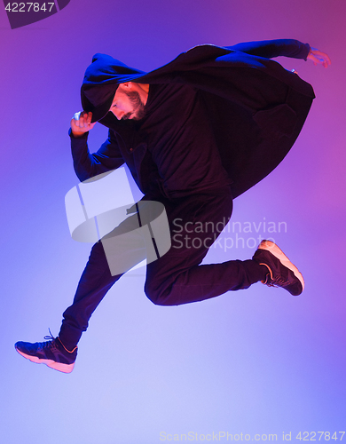 Image of The silhouette of one hip hop male break dancer dancing on colorful background