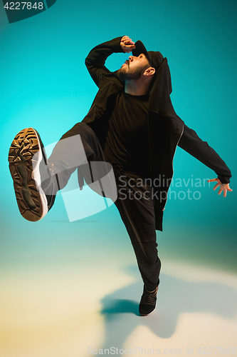 Image of The silhouette of one hip hop male break dancer dancing on colorful background