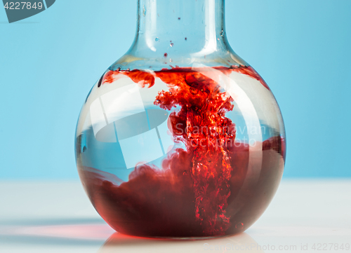 Image of The laboratory glassware and red liquid inside on white