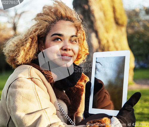 Image of young cute blond african american girl student holding tablet an