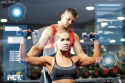 Image of man and woman with dumbbells in gym