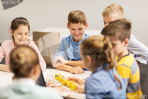 Image of happy children building robots at robotics school