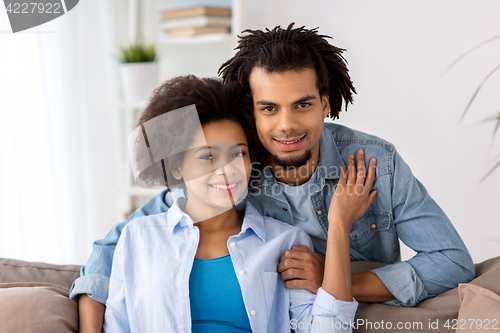 Image of happy couple sitting on sofa at home