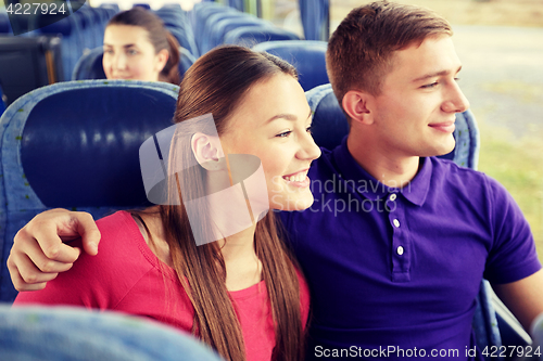 Image of happy teenage couple or passengers in travel bus