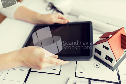 Image of close up of hand with blueprint and tablet pc