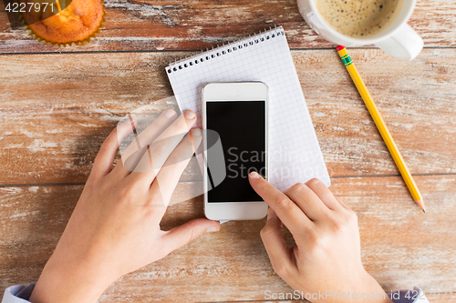 Image of close up of male hands with smartphone on table