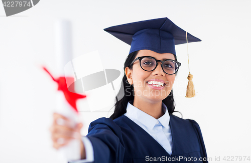 Image of happy bachelor woman in mortarboard with diplomas