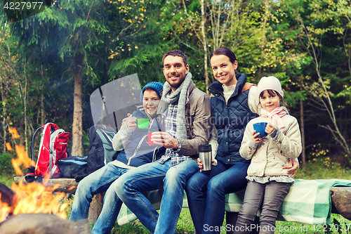 Image of happy family sitting on bench at camp fire