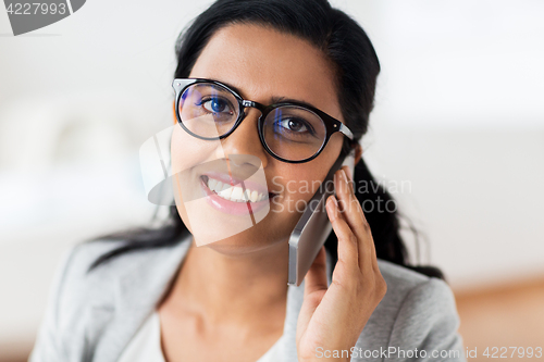Image of businesswoman calling on smartphone at office