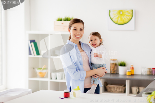 Image of happy mother and little baby girl at home kitchen