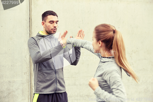 Image of woman with trainer working out self defense strike