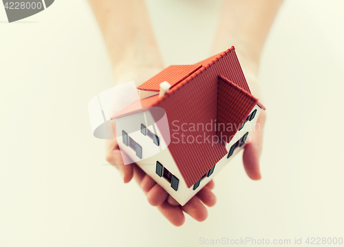 Image of close up of hands holding house or home model