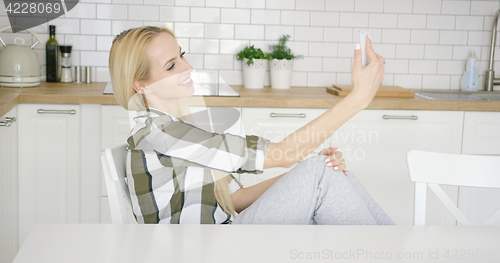 Image of Smiling young female taking self portrait